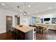 Open concept kitchen and dining area featuring a central island with bar seating and living space at 7730 Tiberon Pkwy, Cumming, GA 30028