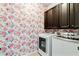 Bright laundry room boasts colorful wallpaper and modern, front-loading washer and dryer at 7730 Tiberon Pkwy, Cumming, GA 30028