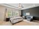 Relaxing main bedroom with neutral carpet, dark accent wall, tray ceiling, and sitting area at 7730 Tiberon Pkwy, Cumming, GA 30028