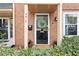 Charming brick townhome entrance featuring a black door with glass and a welcoming wreath at 4418 Chowning Way, Dunwoody, GA 30338