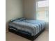 Bedroom with neutral carpet, a blue and gray bedspread, and natural light from the window at 243 Beau St, Lilburn, GA 30047