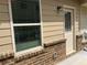 Exterior view of a home showing window and door with brick base at 243 Beau St, Lilburn, GA 30047