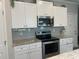 Modern kitchen with white cabinets, stainless steel appliances and granite countertops at 243 Beau St, Lilburn, GA 30047