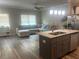 Kitchen with island and stainless steel appliances leading into living room at 243 Beau St, Lilburn, GA 30047