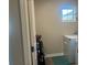 Laundry room with window and tile flooring, featuring a washer and dryer at 243 Beau St, Lilburn, GA 30047