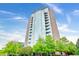 Stunning exterior of tall condo building featuring walls of glass and private balconies against a blue sky at 3300 Windy Ridge Se Pkwy # 1212, Atlanta, GA 30339