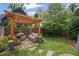 Inviting backyard retreat with pergola, stone patio, wicker furniture, and lush green lawn at 676 Juneberry Se Ln, Atlanta, GA 30316