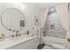 Modern bathroom features a round mirror, shower with curtains, and a clean, white vanity at 676 Juneberry Se Ln, Atlanta, GA 30316
