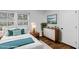 Staged bedroom features a white bed, white and wooden dresser, and lots of natural light at 676 Juneberry Se Ln, Atlanta, GA 30316