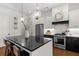 Modern kitchen features an island with a black countertop and stylish globe pendant lights at 676 Juneberry Se Ln, Atlanta, GA 30316