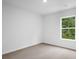 A view of a bedroom with neutral-colored carpeting and white walls with natural light from the window at 8219 Coldstream Dr, Fairburn, GA 30213