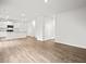 Open-concept living room shows stainless steel appliances, kitchen island, gorgeous flooring, and natural light at 8219 Coldstream Dr, Fairburn, GA 30213