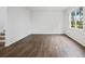 Spacious and bright living room with neutral walls, gorgeous hardwood flooring, base trim, and natural light at 8219 Coldstream Dr, Fairburn, GA 30213