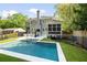 Aerial view of the backyard featuring a pool, outdoor kitchen, screened porch, and wooded views at 1446 Wilford Ne Dr, Atlanta, GA 30319
