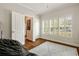 Bedroom with hardwood floors, modern rug, plantation shutters, and interior hall access at 1446 Wilford Ne Dr, Atlanta, GA 30319