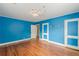 Bedroom with hardwood floors, blue walls, chandelier, and two windows at 3311 Lavista Dr, Hapeville, GA 30354