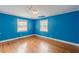 Bedroom with hardwood floors, blue walls, and two windows at 3311 Lavista Dr, Hapeville, GA 30354