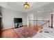 Open-concept living room showcasing hardwood floors and a staircase with a wrought-iron railing at 4605 Heathcliff Way, Cumming, GA 30041