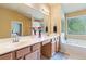 Spa-like bathroom featuring double sinks, a large mirror, and a luxurious soaking tub at 6065 Falls Landing Dr, Cumming, GA 30040
