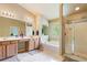 Bright bathroom featuring double sinks, soaking tub, and a separate glass-enclosed shower at 6065 Falls Landing Dr, Cumming, GA 30040