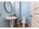 Charming powder room with a pedestal sink, toilet, and painted blue walls at 6065 Falls Landing Dr, Cumming, GA 30040