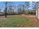 This is a view of a large fenced backyard with a concrete patio and mature trees at 10 Mcgiboney Pl, Covington, GA 30016