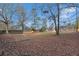 The backyard is fenced with lots of mature trees and leaf coverage at 10 Mcgiboney Pl, Covington, GA 30016