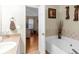 Bright bathroom featuring a large soaking tub with decorative accents and a vanity with view into bedroom at 10 Mcgiboney Pl, Covington, GA 30016