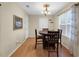 Charming dining area with a round wooden table, chandelier, and natural light from the window at 10 Mcgiboney Pl, Covington, GA 30016
