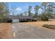 View of long driveway leading up to a brick home with an attached garage and manicured landscaping at 10 Mcgiboney Pl, Covington, GA 30016