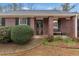 Close-up of a brick facade with black shutters and a welcoming front porch with bench at 10 Mcgiboney Pl, Covington, GA 30016