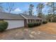 Attached garage of a single-story brick house, complemented by neat landscaping and a long driveway at 10 Mcgiboney Pl, Covington, GA 30016