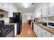 Functional galley kitchen with white cabinets and laminate flooring at 10 Mcgiboney Pl, Covington, GA 30016