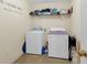 This laundry room features a washer and dryer with a shelf for supplies at 10 Mcgiboney Pl, Covington, GA 30016
