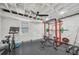 Basement gym with stone accent wall, weight rack, stationary bike, weights, ceiling fan, and rubber flooring at 2193 Cloverdale Se Dr, Atlanta, GA 30316