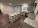 Modern kitchen boasts an island, gray cabinets, granite countertops, and stainless steel appliances at 30 Barton Ln, Covington, GA 30016
