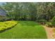 Lush backyard featuring a well-maintained lawn, garden beds and mature trees at 3772 Evans Rd, Atlanta, GA 30340