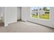 Bright, carpeted bedroom with large window, white trim, and view of the backyard at 8228 Coldstream Dr, Fairburn, GA 30213
