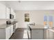 Open kitchen with white cabinets, stainless steel appliances, and a large island at 8230 Coldstream Dr, Fairburn, GA 30213