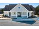 A detailed shot of a gray pool house with white trim, stone accents, and a gated entrance to the pool at 8230 Coldstream Dr, Fairburn, GA 30213