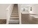 Carpeted stairway leading up to the second floor, with a view of the kitchen at 8230 Coldstream Dr, Fairburn, GA 30213