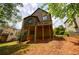 Backyard view of the home with a deck, natural landscaping, and mature trees at 1523 Fallen Leaf Dr, Marietta, GA 30064