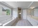 Bright bathroom featuring a tub with a window, walk-in shower, tile floors, and dual sink vanity at 1523 Fallen Leaf Dr, Marietta, GA 30064
