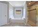 Bright bathroom featuring a tub with a window and walk-in shower at 1523 Fallen Leaf Dr, Marietta, GA 30064