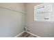 Compact laundry area with vinyl flooring, window, and shelving for storage and natural light at 1523 Fallen Leaf Dr, Marietta, GA 30064