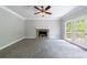 Living room with a stone fireplace, soft carpeting, and doors to an outdoor deck at 1523 Fallen Leaf Dr, Marietta, GA 30064