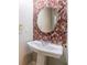 Stylish powder room with vessel sink, round mirror, and unique mosaic tile wall at 1523 Fallen Leaf Dr, Marietta, GA 30064