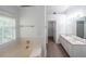 Bathroom featuring a soaking tub, double sink vanity, and walk-in closet at 1528 Rogers Crossing Dr, Lithonia, GA 30058