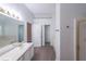 Bright bathroom featuring double sinks, a tub and shower, and wood-look floors at 1528 Rogers Crossing Dr, Lithonia, GA 30058