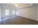 Spacious main bedroom featuring a tray ceiling, ceiling fan, and carpeted flooring at 1528 Rogers Crossing Dr, Lithonia, GA 30058